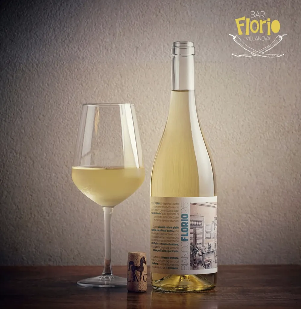 La bottiglia di Bianco Florio 25 accanto a un calice di vino bianco e al tappo di sughero della Cantina La Giara
