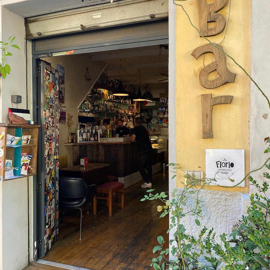 L'ingresso del Bar Florio in via San Domenico: la porta aperta sul banco di legno e le lettere in legno della parola Bar sul muro giallo